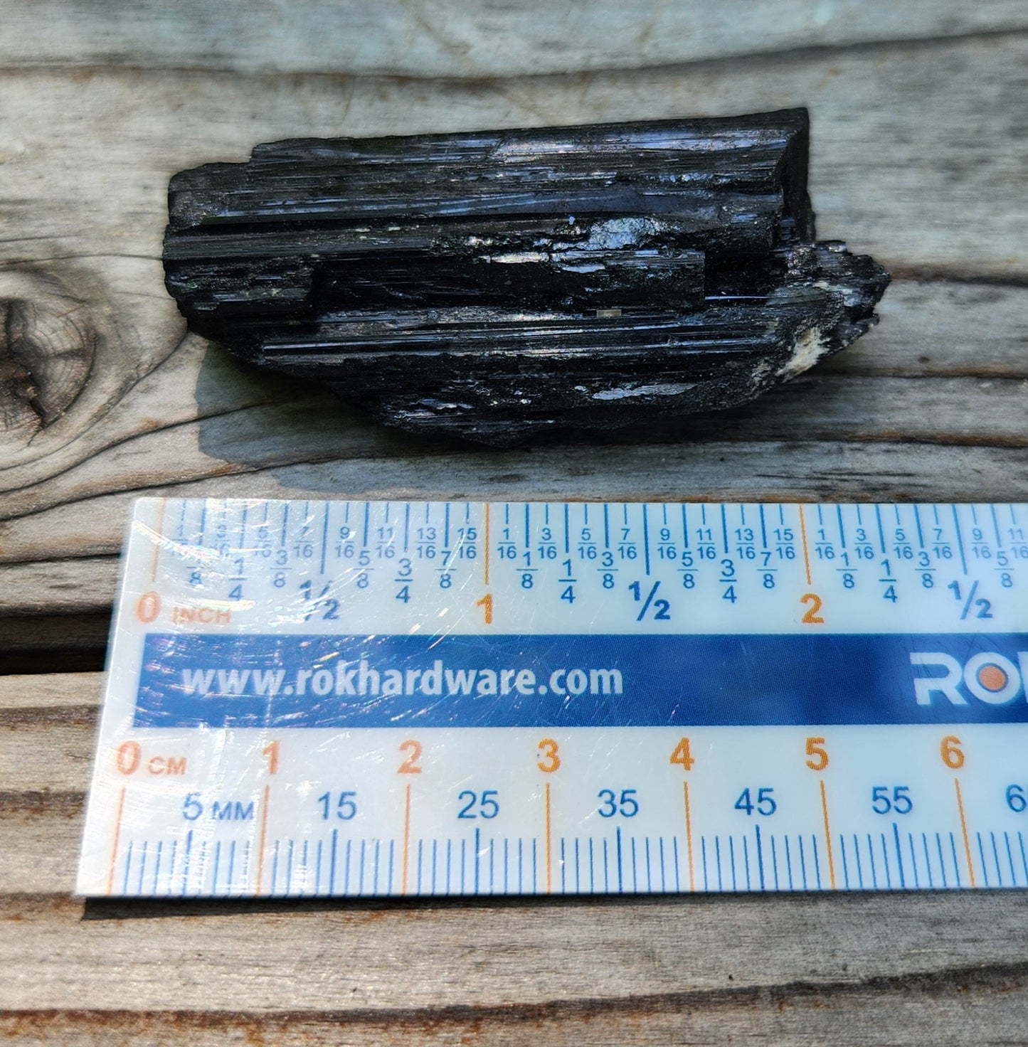 Rough black tourmaline mineral specimen with ruler for size, item RC425