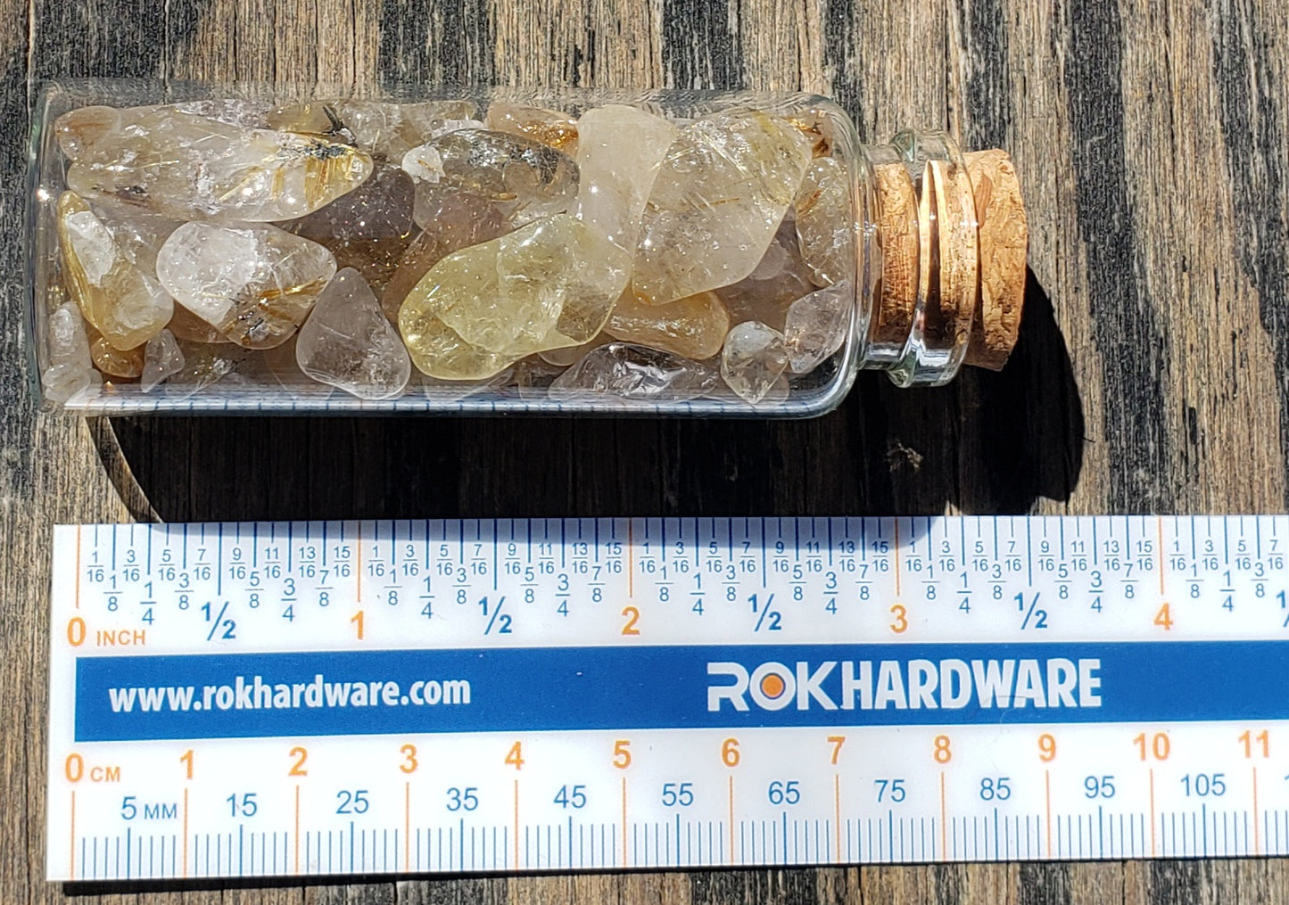 Large assortment of polished Rutilated Quartz tumbled stones in a display jar with ruler for reference, JJRRQ