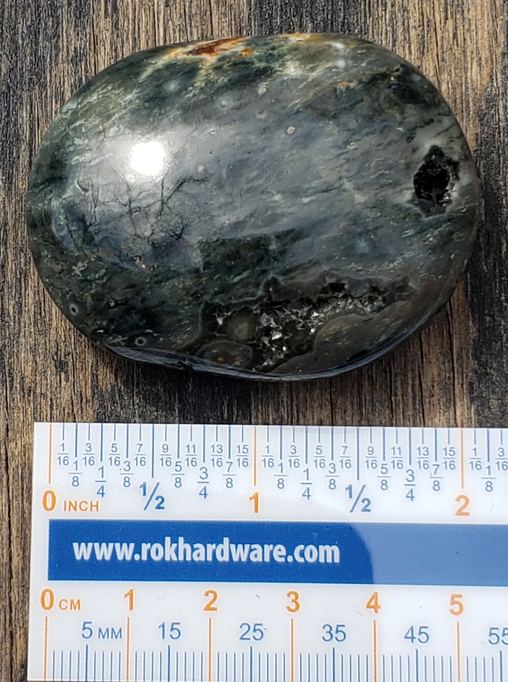 A polished Ocean Jasper palm stone with ruler PS08-3