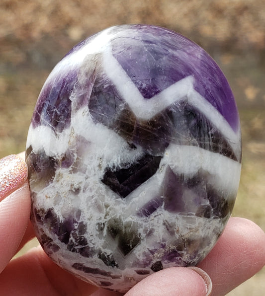 Polished chevron amethyst palm stone highlighting natural banding and smooth finish PS07-1