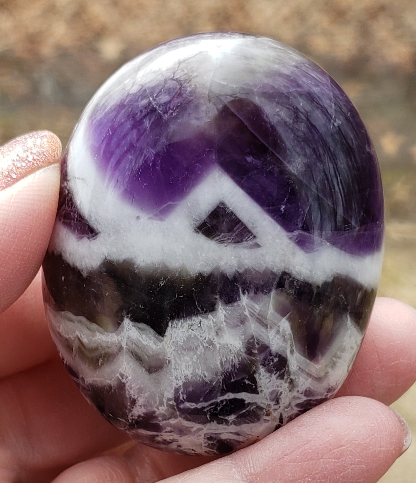 Polished chevron amethyst palm stone highlighting natural banding and smooth finish PS07-2
