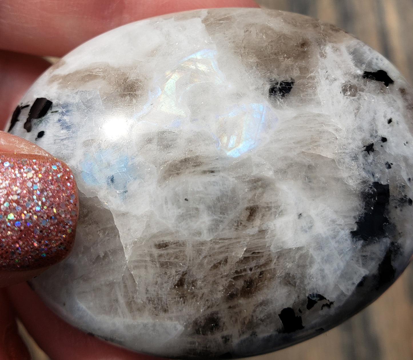 Rainbow moonstone palm stone showing soft white color with subtle blue flash in natural light PS06-5