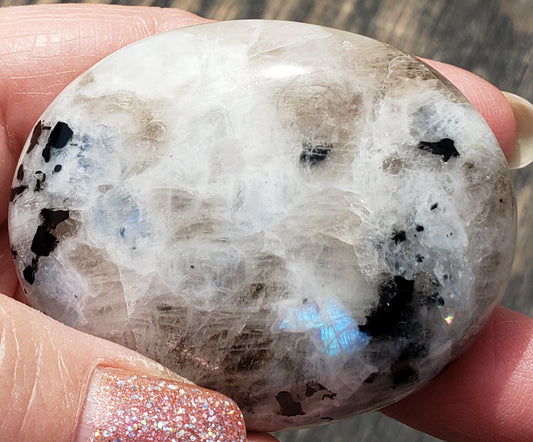 Rainbow moonstone palm stone showing soft white color with subtle blue flash in natural light PS06-3