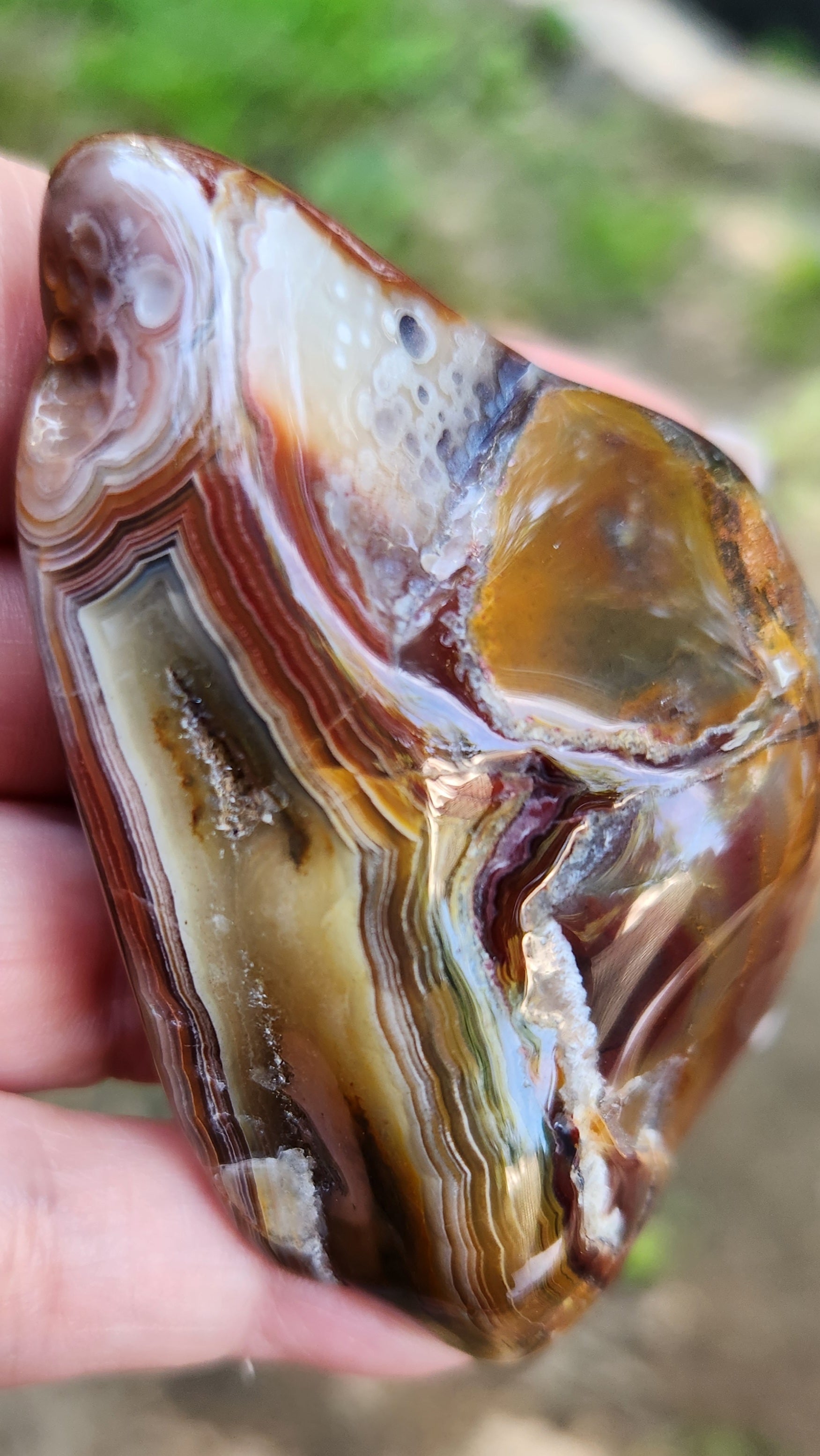 Natural banded agate displayed in hand, TA355