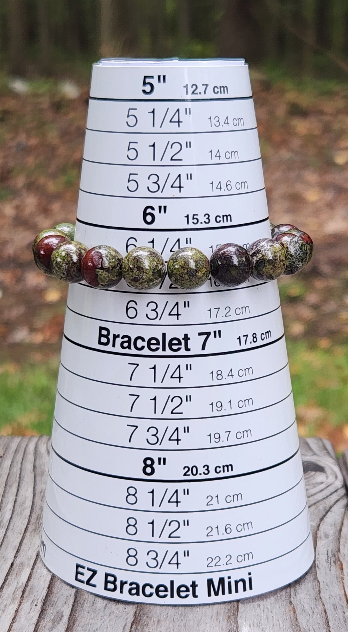 Handmade Dragon’s Blood stretch bracelet displayed on bracelet sizer
