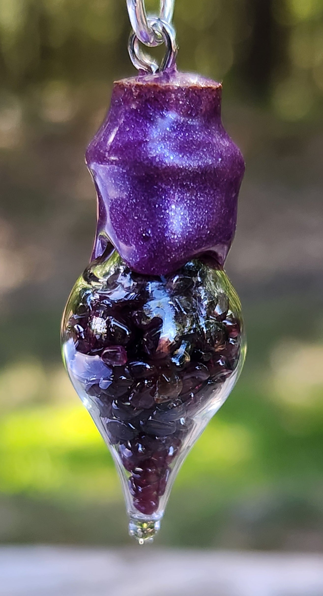 Tumbled garnet gemstone necklace in glass bottle pendant close up