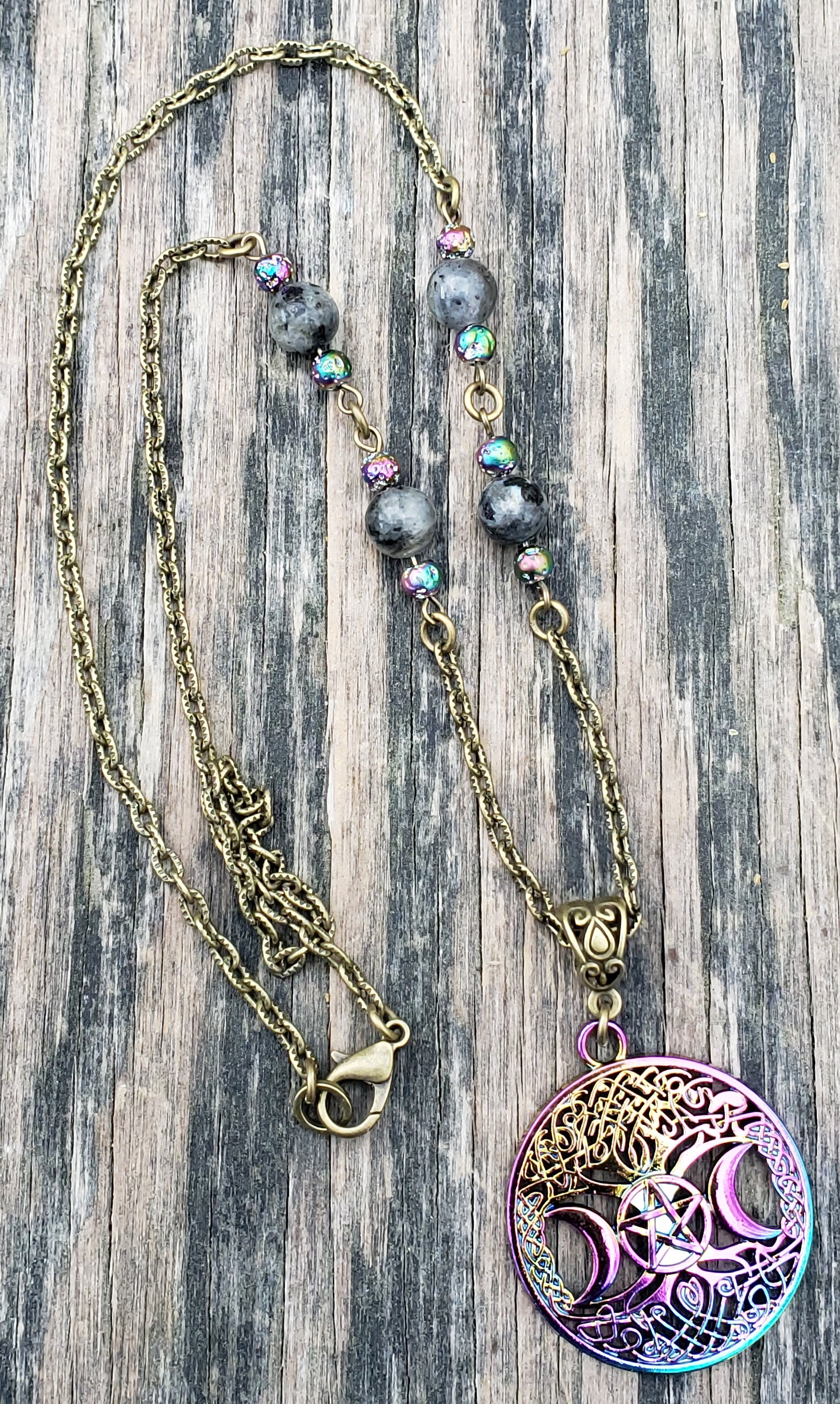A rainbow plated triple moon wiccan pagan necklace with larvikite beads and a bronze-colored iron chain