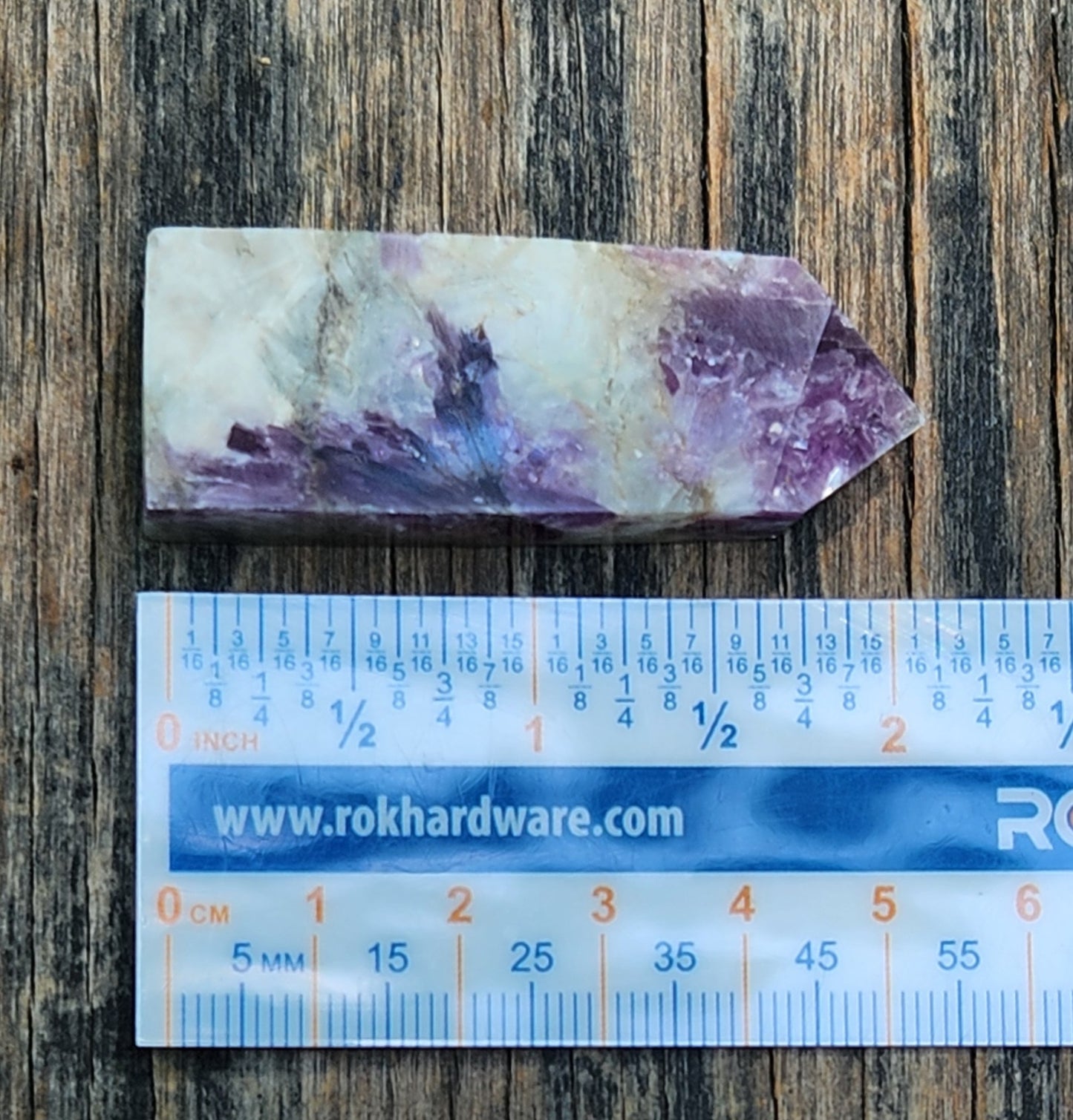 Polished lepidolite crystal tower showing ruler for size, CV316