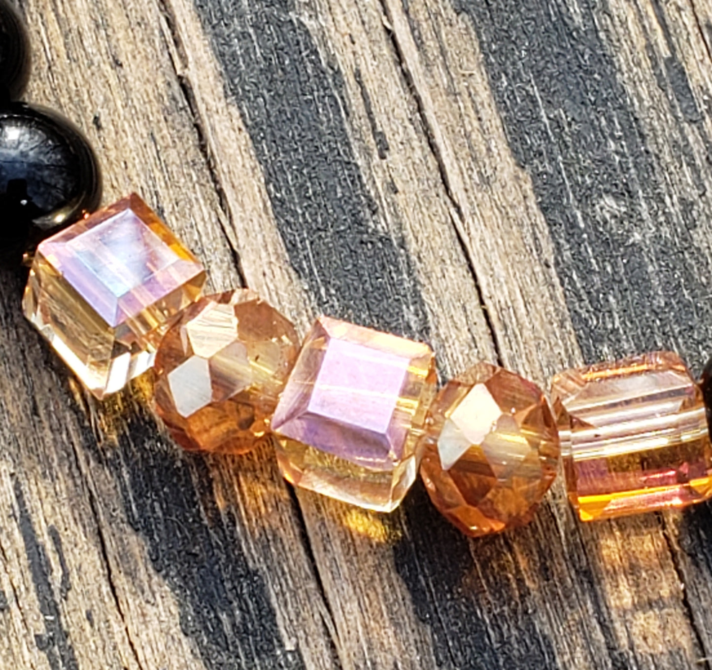 Pink, orange & black glass stretch bracelet beads close up