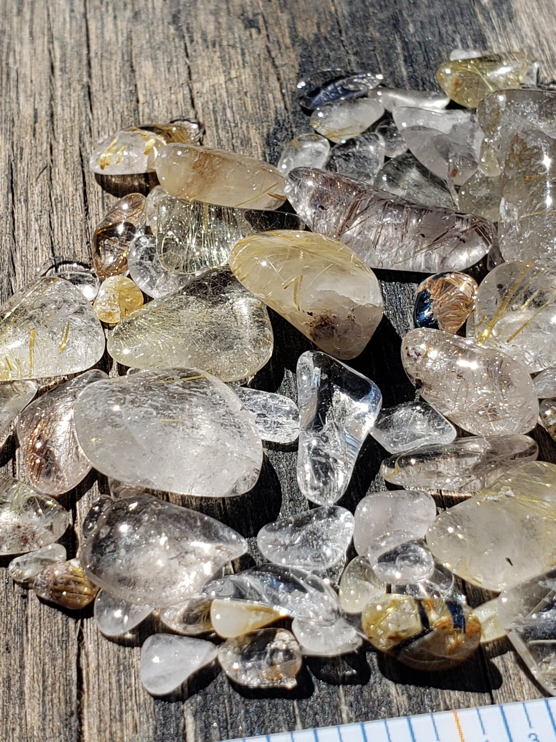Close-up of tumbled Rutilated Quartz stones with internal rutile inclusions, JJRRQ