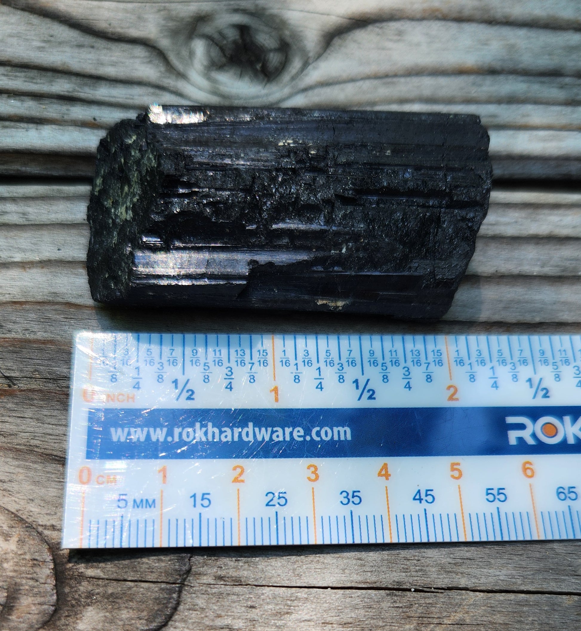 Rough black tourmaline mineral specimen with ruler, item RC423