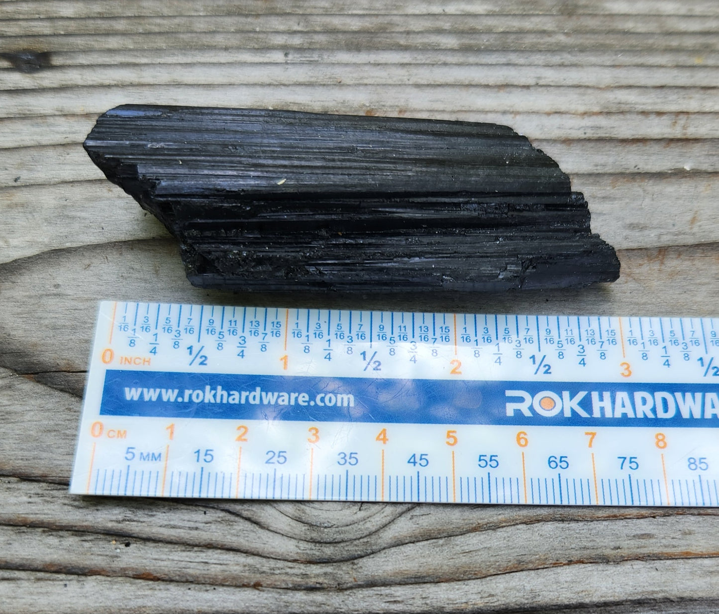 Rough black tourmaline mineral specimen with ruler for size, item RC428