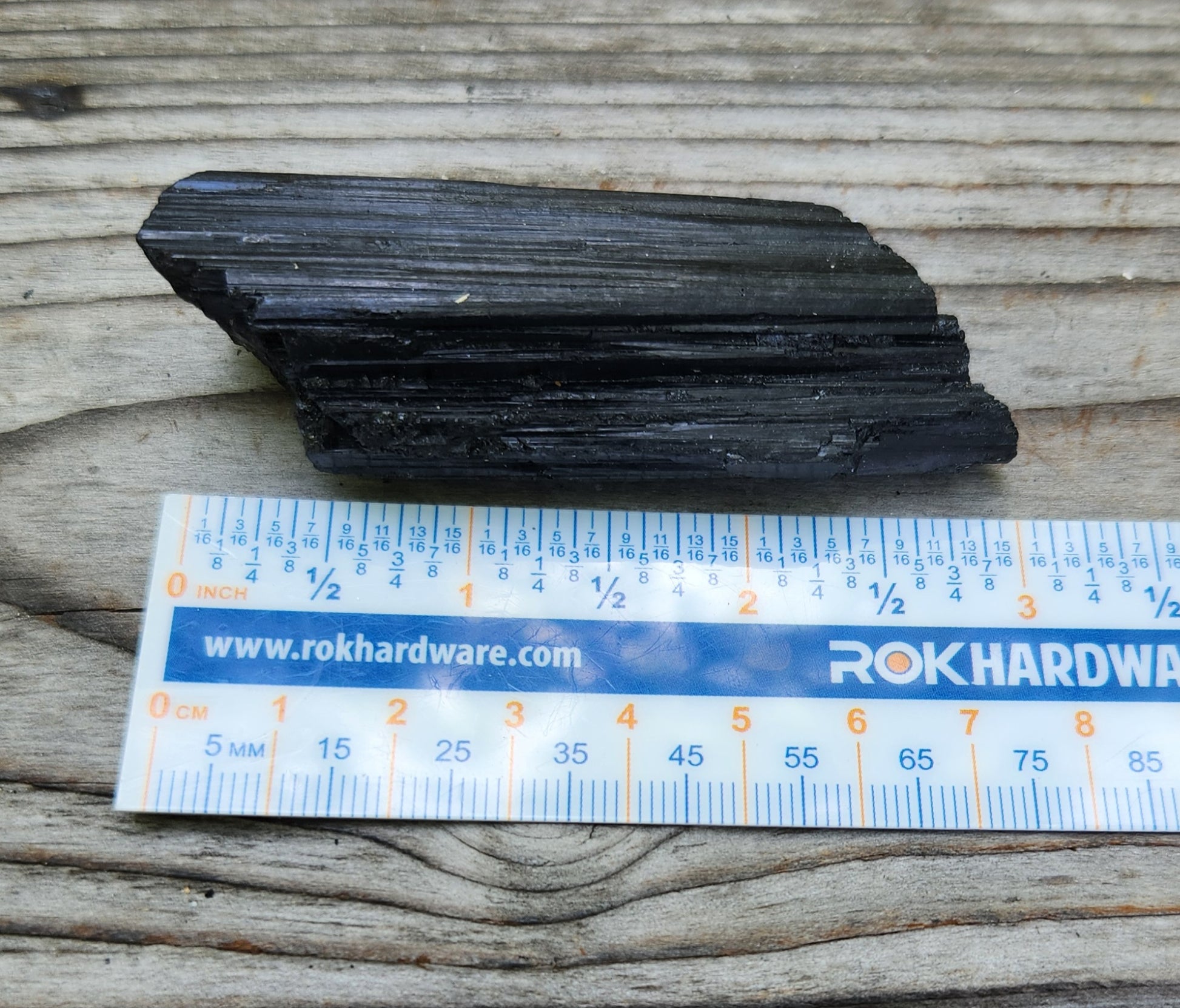 Rough black tourmaline mineral specimen with ruler for size, item RC428