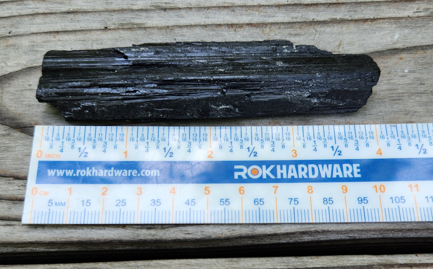 Rough black tourmaline mineral specimen with ruler for size, item RC429