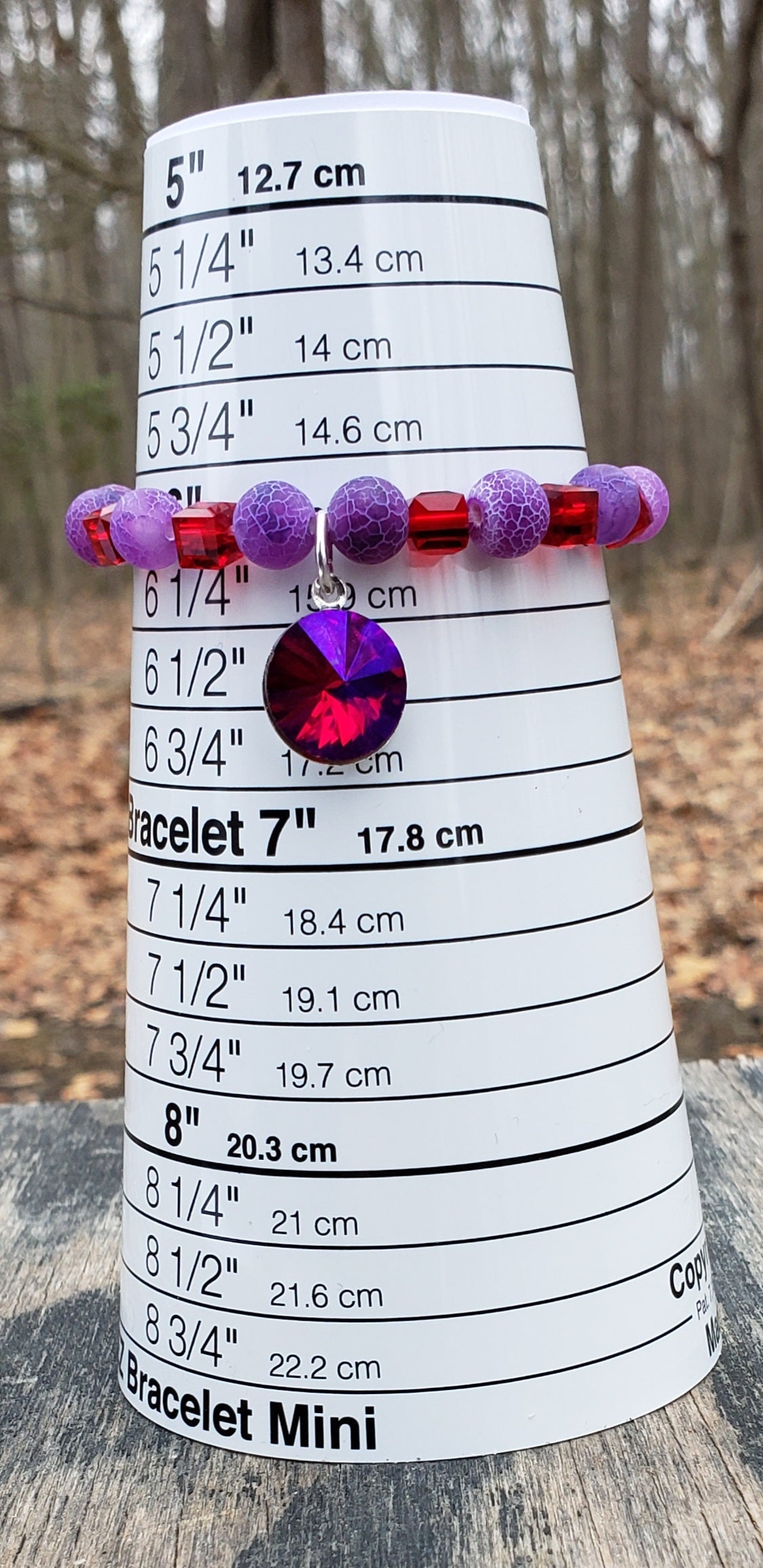 Purple beaded agate bracelet on a ruler for measurement