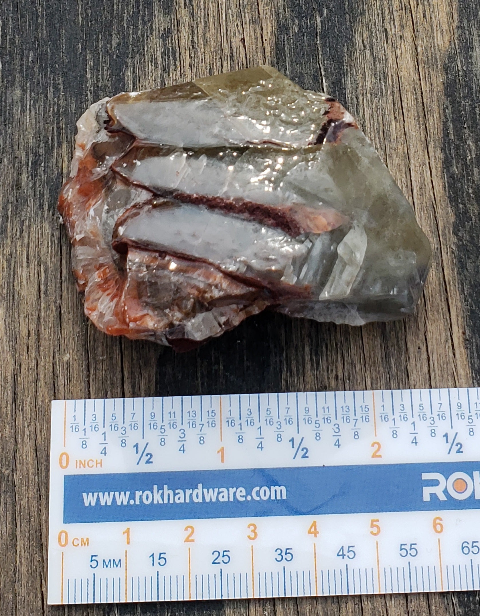 Tri-color calcite rough rock specimen with ruler for size
