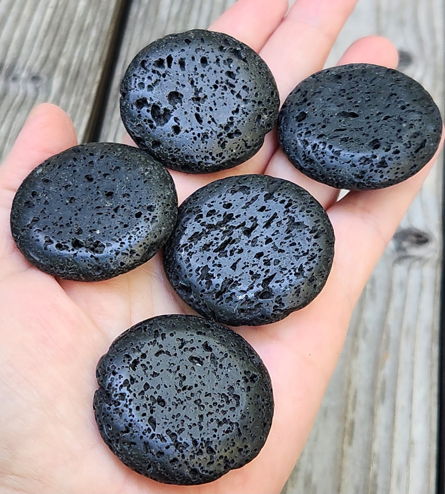 Natural lava rock palm stone with volcanic texture in hand
